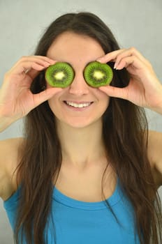 Beautiful young girl is holding kiwi fruit