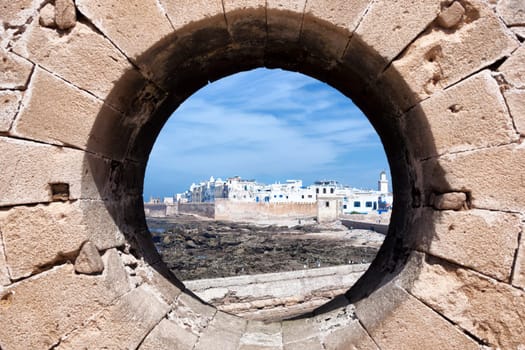 View of the coastal town Essaouira through a rampart hole.