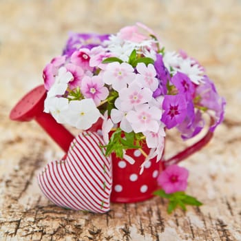 Small red jug with colorful flame flowers and a heart