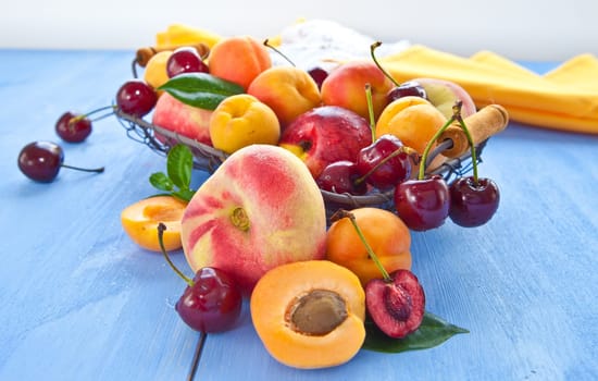 Different types of peaches,cherries and apricots in a wire body