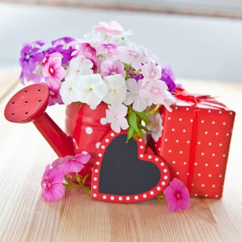 Fresh colorful flowers,small gift and a heart with text space