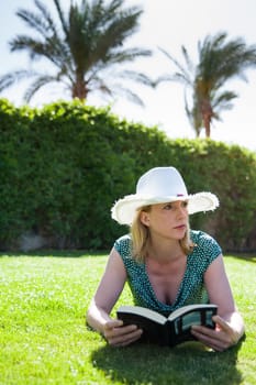 Woman with book under palm trees
