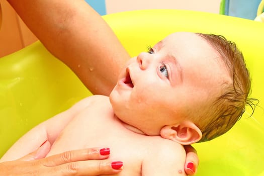 Mom giving comforting bath to her baby