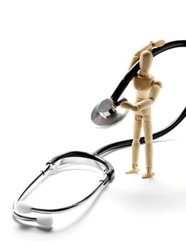 Wooden mannequin holding a stethoscope