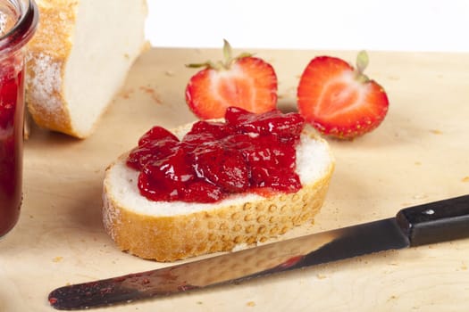 White bread with homemade strawberry jam on a wooden board