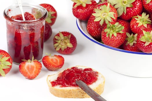 Strawberries,strawberry jam and fresh white bread insulated against a white background