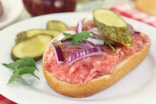 a Mettbrötchen with onion and cucumber