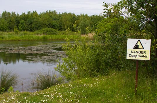 danger sign next to a lake