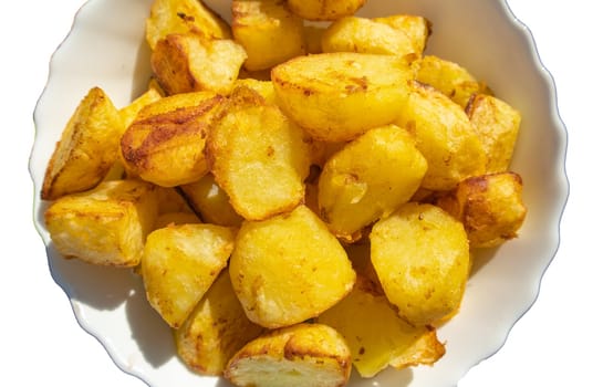 A pile of fried potatoes, cut into large slices, cut out and isolated on a white background.