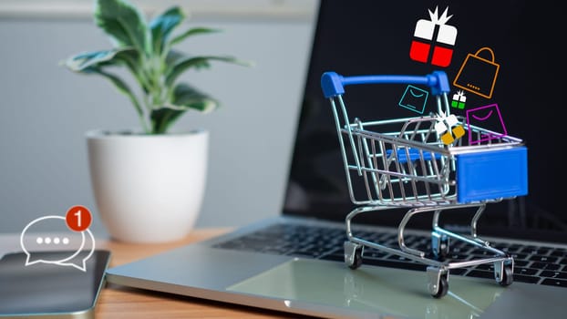 Shopping cart and gift box icons placed on laptop computer represent  online shopping concept, website, e-commerce, market platform, technology, , shipping, logistics and online payment concept.