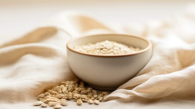 A bowl of oatmeal and oats on a linen cloth