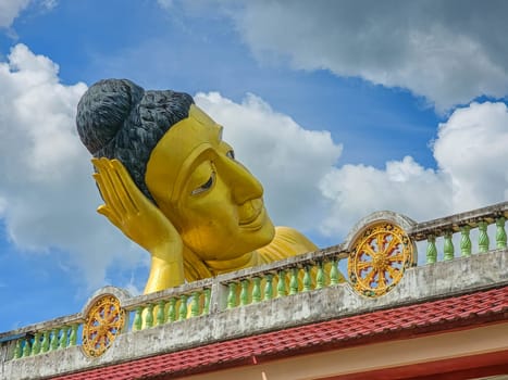 Head of big lying golden Buddha statue at Wat Sri Sunthon temple by day, Phuket, Thailand