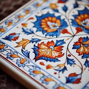 A close up of a colorful tile with blue, orange and red flowers