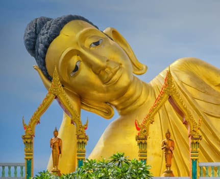 Head of big lying golden Buddha statue at Wat Sri Sunthon temple by day, Phuket, Thailand