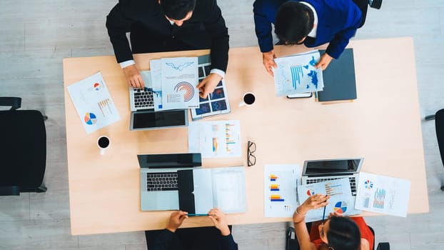 Business people group meeting shot from top view in office . Profession businesswomen, businessmen and office workers working in team conference with project planning document on meeting table . Jivy