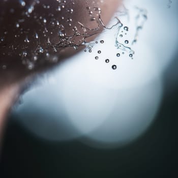 A close up of a man's face with water droplets