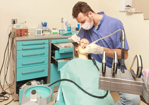 Dentist doctor drilling tooth in dental clinic