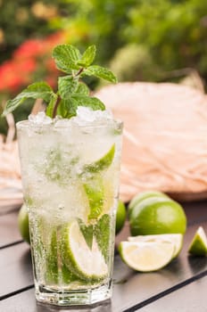 Refreshing Mojito cocktail after gardening with a straw hat at the background