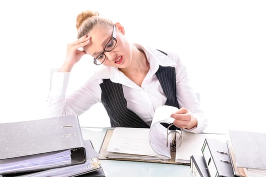 Young woman with blond hair in a business suit (tax consultant,manager,secretary) sits at her desk and pores over a stack of files against a white background.