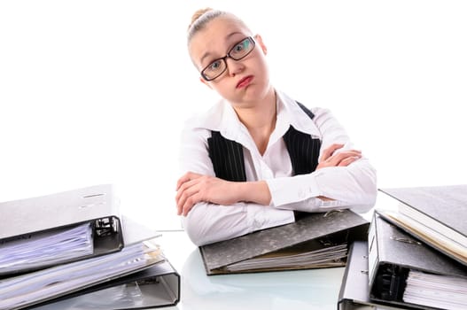 Young woman with blond hair in a business suit (tax consultant,manager,secretary) sits at her desk and pores over a stack of files against a white background.