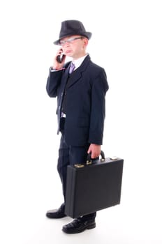 A teenage boy wears a black suit,hat and briefcase and makes phone calls,isolated against a white background.