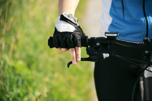 young woman training on mountain bike and cycling in park. Copy space, cropped view