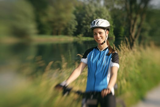 young woman training on mountain bike and cycling in park. Copy space, low angle view