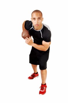 A young Jamaican football player in his black outfit standing for.white background with his football under his arm..