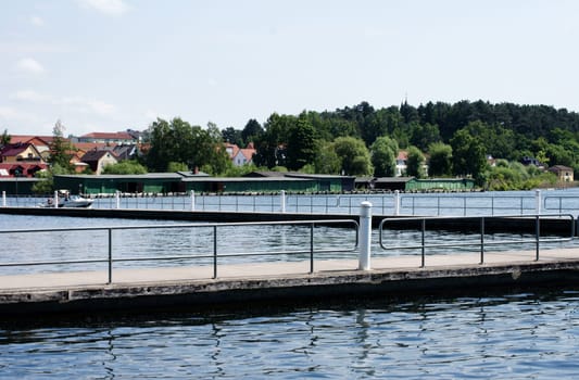 The photograph of a concrete walkway or a viewing platform with railing on a lake.