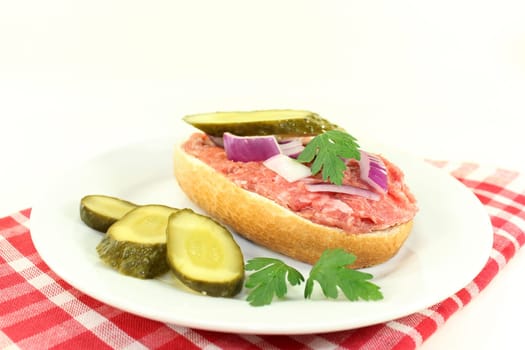 a Mettbrötchen with onion and cucumber