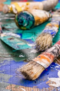 Brushes,spatula and oil paints on a wooden pallet