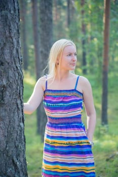 Woman in lined dress next to tree stem