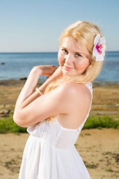 Youthful woman with white flower in gold hairs