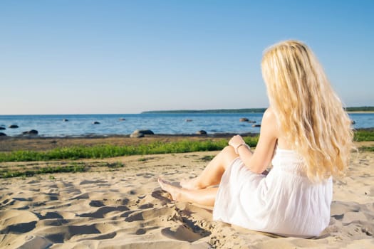 Woman in white dress looking at early sunset
