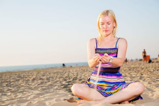 Woman in dress traverse the sand by hands