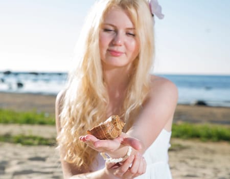 Woman in white dress looking at brown clam