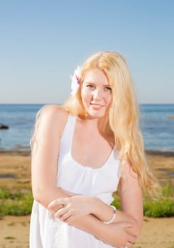 Woman in white dress at blue sea background