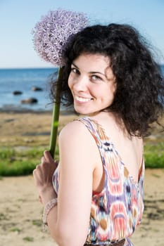 Young woman with dark hairs posing with flower
