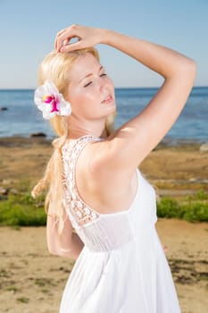 Youthful woman in dress with flower in hairs