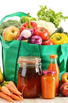 Green shopping bag with grocery products on white background
