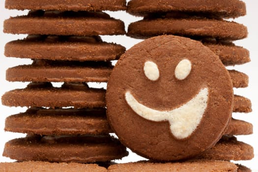 Closeup shot of a brown cookie with smiling face on it.
