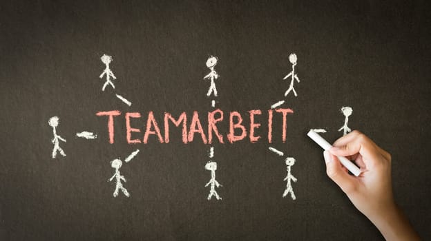 A person drawing and pointing at a Teamwork Chalk Drawing