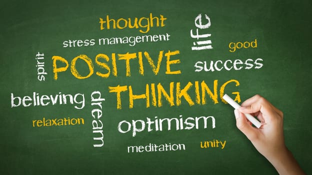 A person drawing and pointing at a Positive Thinking Chalk Drawing