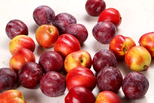 Nectarines and Plums on the kitchen table background.