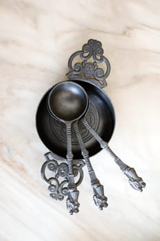 The close-up of zinc spoons in a metal bowl.