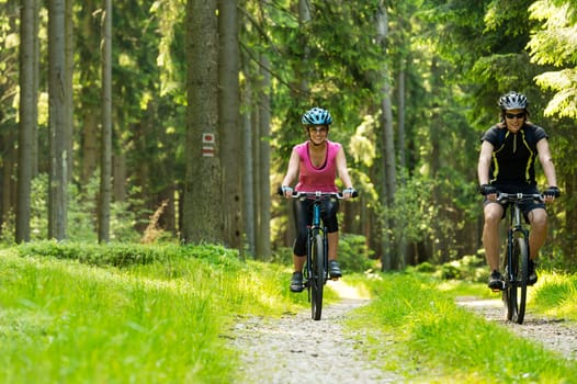Young cheerful biker couple in woods