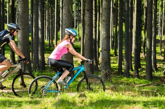 Young sporty biker couple in woods sunny day in countryside