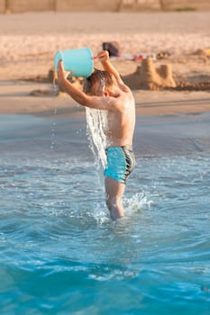 Hot summer - little boy splashing on the beach