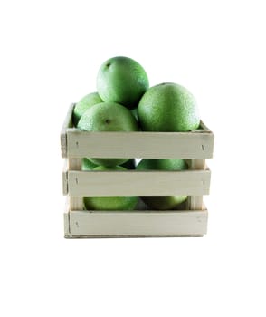 Green pomegranates in a wood box on white background.