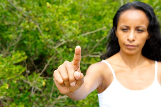 Young latin woman pointing with a finger in the air.